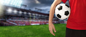 Un calciatore con un pallone sotto il braccio