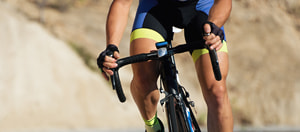 Un ciclista in azione e il logo di Sisal