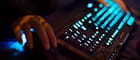 Una mano e una tastiera di computer illuminata al neon