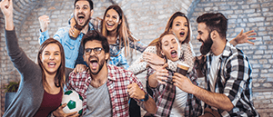 Ragazzi e ragazze che esultano mentre assistono a un match di calcio