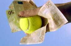 Una mano che stringe delle banconote da 50 euro e una pallina da tennis
