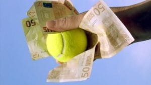 Una mano che stringe delle banconote da 50 euro e una pallina da tennis