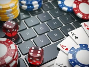 Chips, carte da gioco e dadi appoggiati su una tastiera di computer