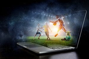 Un laptop con dei giocatori di calcio che escono dallo schermo