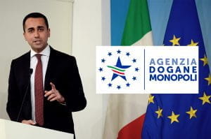 Il Ministro del Lavoro Luigi Di Maio, le bandiere di Italia e Europa e il simbolo dell'Agenzia Dogane e Monopoli