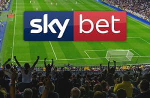 Uno stadio affollato durante una partita di calcio e il logo di Sky Bet