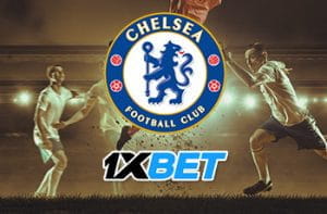 Il logo del Chelsea, il logo di 1XBET, dei calciatori in azione sullo sfondo
