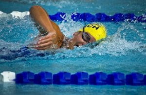 Una nuotatrice con la cuffia gialla in azione