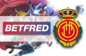 Calciatori in azione e i loghi di Betfred e RCD Maiorca