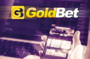 Il logo di GoldBet, uno smartphone con un sito di scommesse
