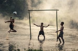 Alcuni bambini che giocano a calcio in riva al mare