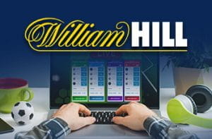 Una persona davanti a un laptop e il logo di William Hill