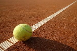 Una pallina da tennis rimbalza su un campo di terra rossa