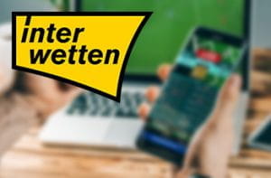 Il logo di Interwetten e uno smartphone collegato a un bookmaker online
