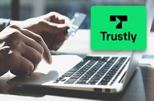 Il logo di Trustly e la tastiera di un computer