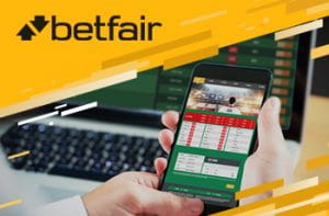 Il logo di Betfair e uno smartphone sulla pagina di un bookmaker online