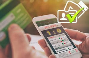 Scommesse su smartphone con logo di verifica ID.