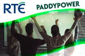 Ragazzi che guardano una partita di calcio alla tv, logo RTÉ e logo Paddy Power.