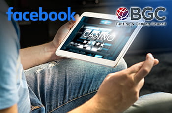 Ragazzo con dita incrociate che gioca al casinò online su un tablet, logo di Facebook e logo BGC.