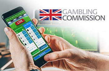 Scommesse sportive su smartphone, bandiera inglese e logo Gambling Commission