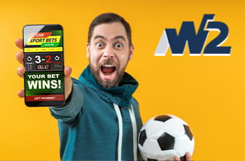 Ragazzo che scommette online con uno smartphone e un pallone in mano, logo W2