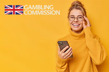Ragazza con in mano uno smartphone, logo Gambling Commission