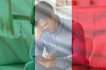 Ragazzo con smartphone in mano e faccia triste, bandiera italiana