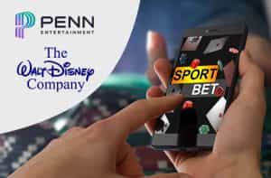 Smartphone su una pagina di scommesse sportive, logo Walt Disney Company e logo su Penn Entertainment