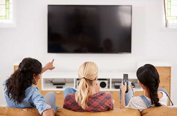 Tre ragazze che guardano la TV