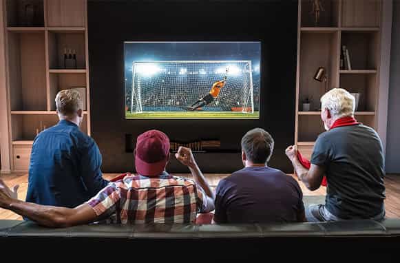 4 persone sul divano che guardano una partita di calcio