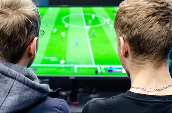 Due ragazzi che giocano a un videogame di calcio