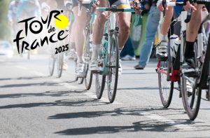 Ciclisti in gara e logo Tour de France 2025