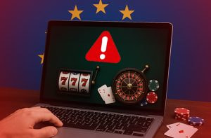 Computer con simboli di gioco su schermo e segnale di divieto