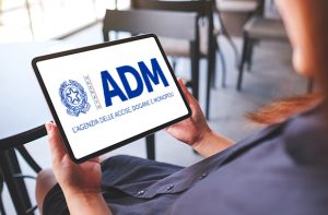 Una donna tiene in mano un tablet con il logo ADM