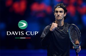 Il tennista Lorenzo Musetti e il logo della Coppa Davis