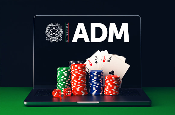 Fiches e carte poggiate su un laptop aperto con logo ADM su schermo