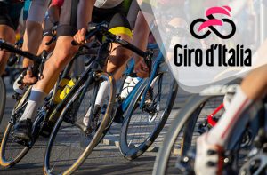 Ciclisti in corsa inquadrati dal basso e logo del Giro d’Italia